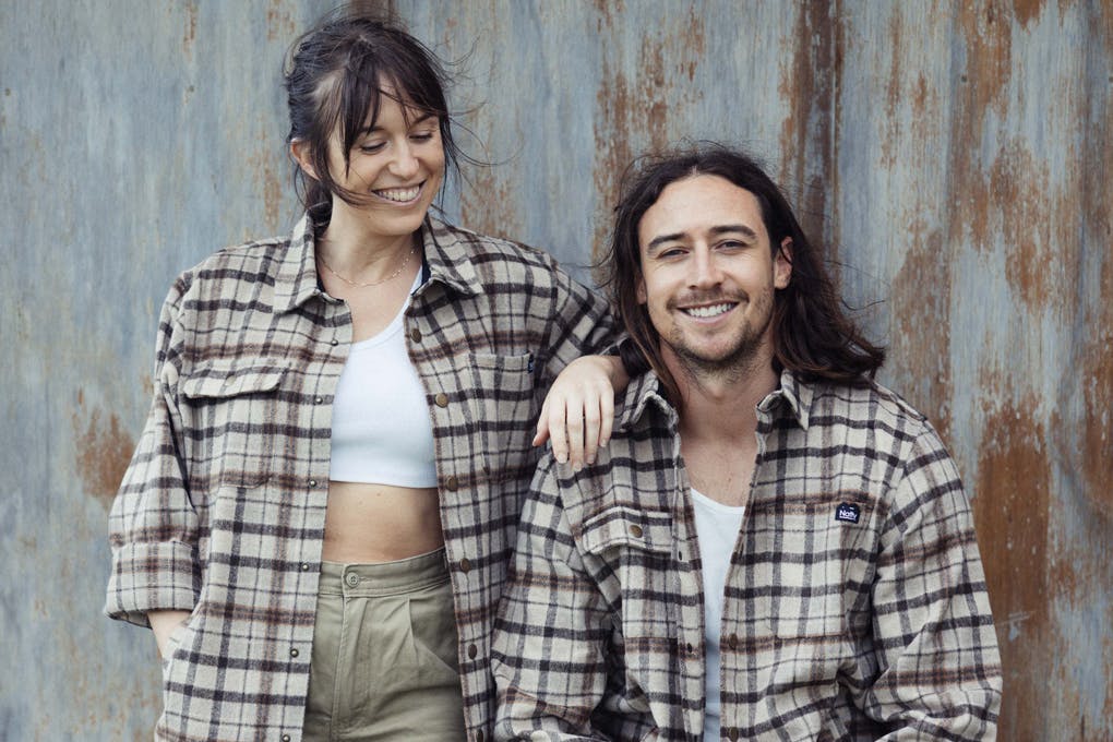 Two people in flannel shirts smiling.